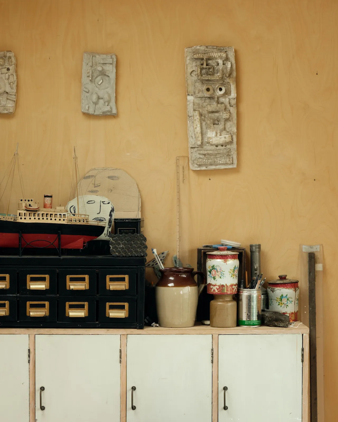 A series of Paolozzi moulds are mounted on the wall of christopher's drawing studio