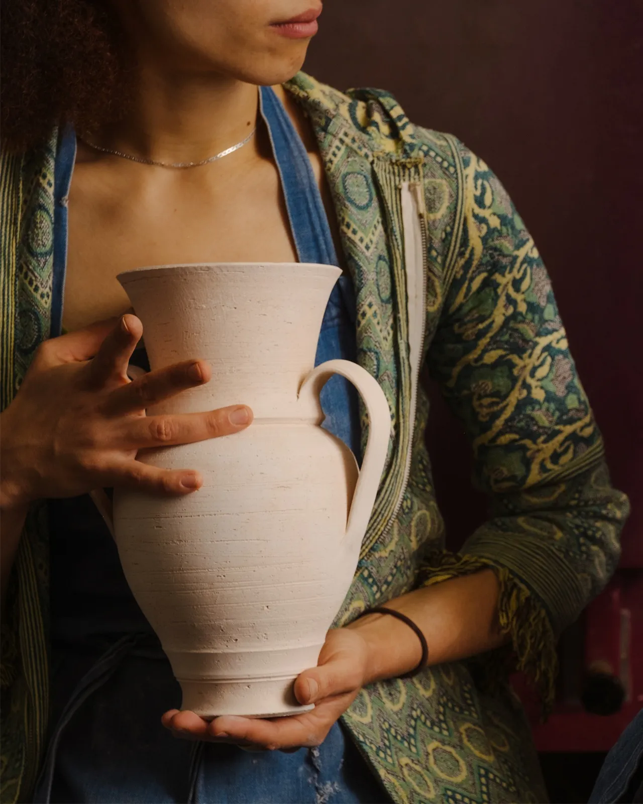 Freya builds the pot on the wheel and then hand builds the handle