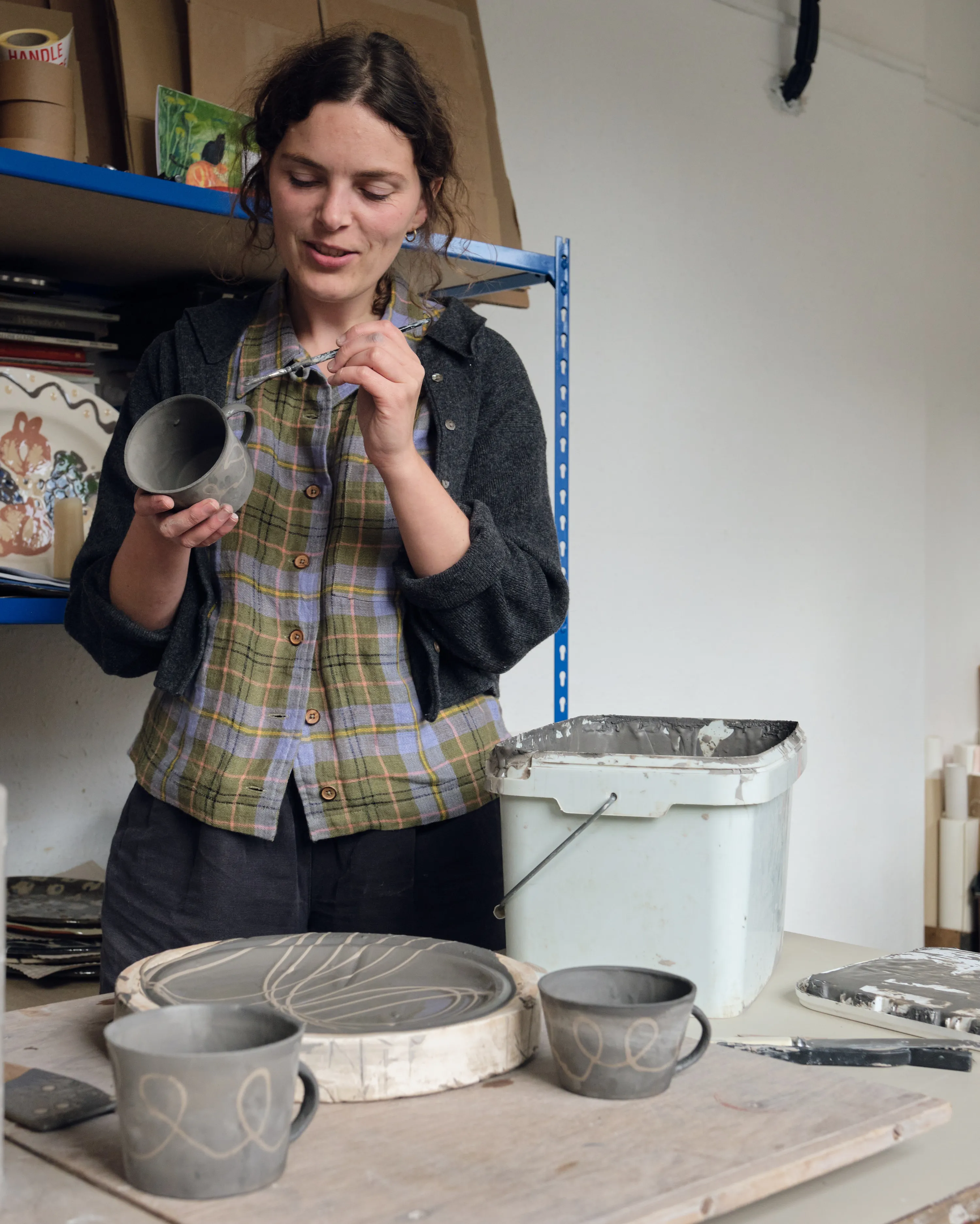 Ali paints the handles of her slipware coffee cups