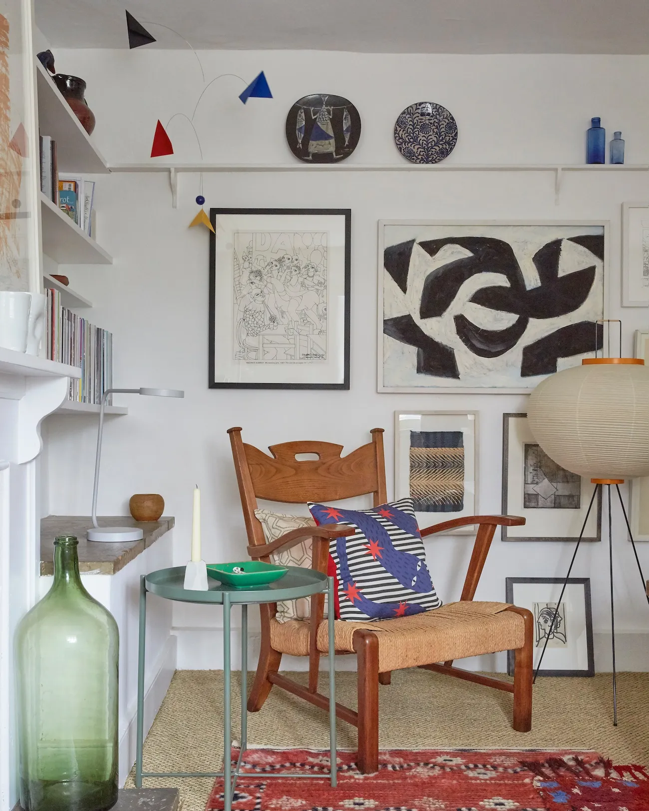 The shelf at picture-rail height was a relic of the former tenant, which Tobias kept as a display. Here a Noguchi lamp sits with an MMF rug and Paolo Buffa chair in the sitting room.
